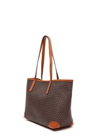 Torebka typu tote z ciemnym geometrycznym wzorem, brązowymi skórzanymi akcentami, dwiema długimi rączkami i przestrzennym prostokątnym kształtem.