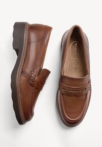 Paire de mocassins en cuir marron avec semelles en caoutchouc foncé, une chaussure vue de côté et l'autre de dessus.