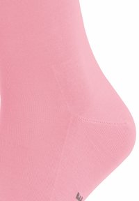 Calzino di cotone rosa con una trama liscia e un design aderente, dotato di punta rinforzata. Sottile branding in nero vicino al polsino.