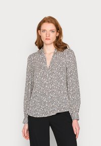 Langarm blouse met een V-hals en een multikleurig dierenprint op een witte achtergrond. Lichtgewicht stof, losse pasvorm en met knoopmanchetten.