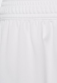 Pantalones cortos deportivos blancos hechos de una tela suave y lisa. Cuentan con una cinturilla elástica y sutiles pliegues cerca del dobladillo para mayor comodidad.
