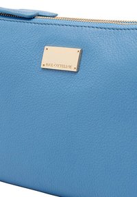 Blauwe leren clutch met een textuurafwerking, voorzien van een gouden metalen plaat met gegraveerde tekst en een rits aan de bovenkant.