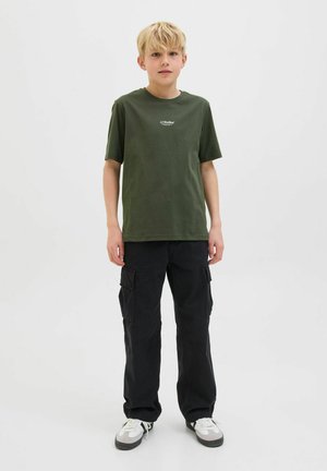 Olivgrön bomull t-shirt med korta ärmar och en liten vit logga, tillsammans med svarta cargobyxor med sidofickor och vita sneakers.