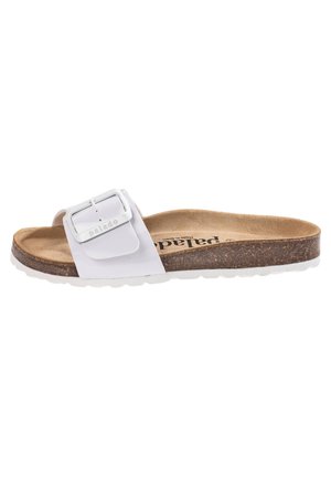 Sandalia de playa blanca con una correa ancha y hebilla metálica, plantilla de corcho y suela de goma blanca. Textura suave con un diseño minimalista.
