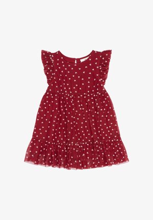 Crvena haljina s kratkim volanima, koja ima bijeli uzorak srca, strukiranu struku i plisiranu rubnu volan. Zatvaranje na zatvarač na leđima.