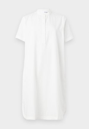 Robe blanche à manches courtes en coton, avec un col montant, une patte de boutonnage et des poches latérales, au fit décontracté et à la coupe droite.