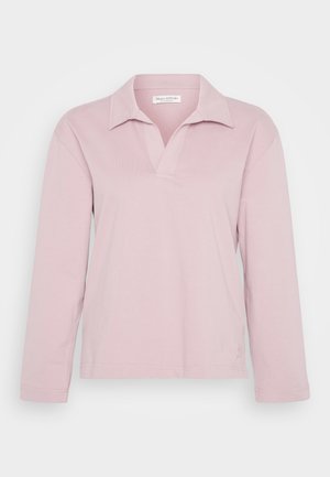Polo à manches longues rose clair avec un col en V, fabriqué en tissu doux, avec une coupe ample et des détails de couture en bas.