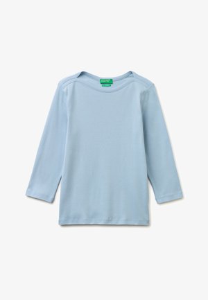 Jasnoniebieska bawełniana koszula z długim rękawem, okrągłym dekoltem i widocznym przeszyciem, ułożona na płasko na białym tle.