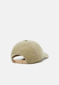 Kaki bomull baseball cap med en buet skjerm, justerbar lys beige plastrem, og bakre sømdetaljering som sier "EST 1922."