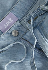 Světlé modré džíny z denimu s kovovým knoflíkem, zipem, šňůrkou a fialovou textilní štítkem s nápisem JJXX.