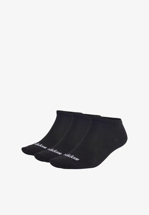 Calcetines negros hasta el tobillo de tela suave. Tres pares visibles, con un logo blanco en el frontal. Textura suave y diseño ajustado.