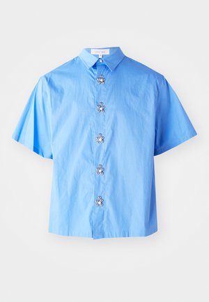 Light blue short-sleeve blouse made of cotton, featuring floral-shaped metallic buttons along the front and a classic collar design.
