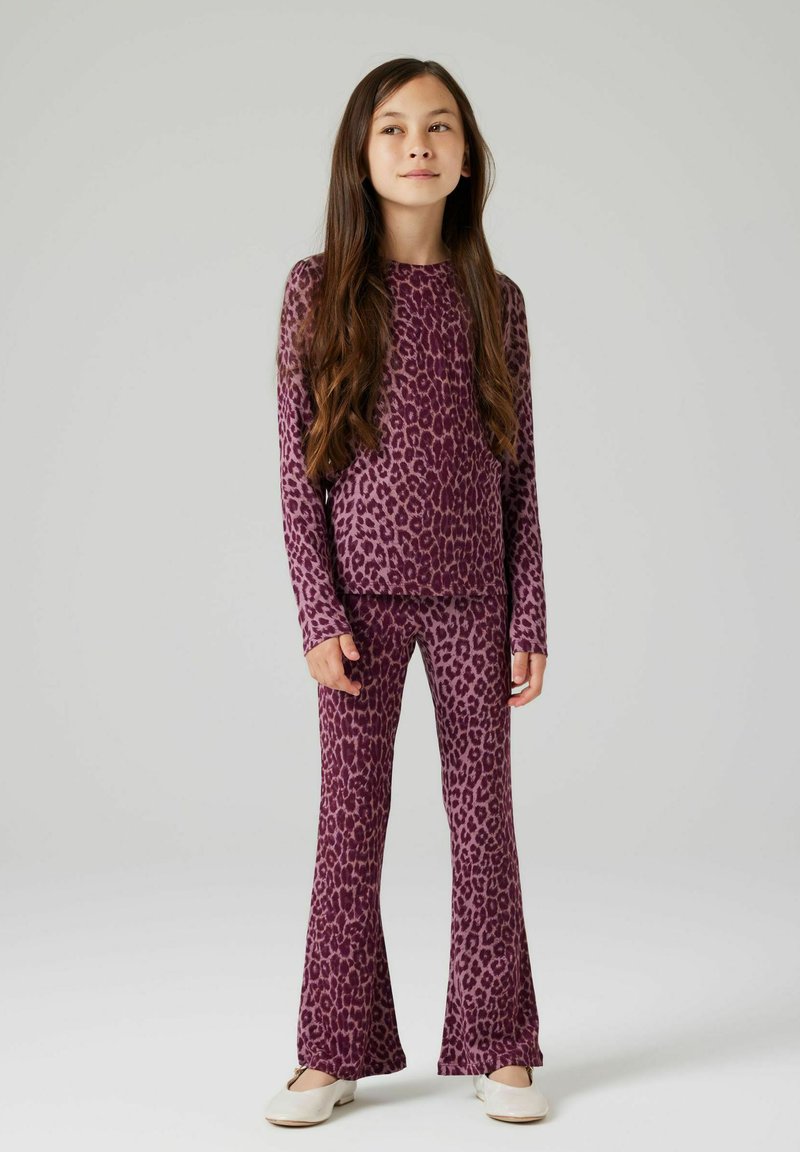 Lilla leopardmønstret loungewear sæt med langærmet top og flagrende bukser. Blødt stof, afslappet pasform og et karakteristisk dyremønster.