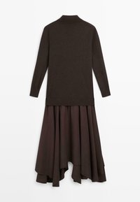 Bruine jurk met lange mouwen, voorzien van een gebreide top en een vloeiende rok met een hoog-laag zoom, gemaakt van lichtgewicht stof met een gladde textuur.