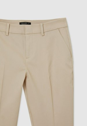 Pantalons beige ajustés avec une texture subtile, deux poches latérales et des passants de ceinture. Présente un design à jambe droite et une fermeture éclair.