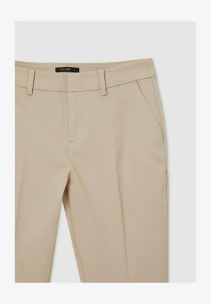 Pantaloni beige su misura con una sottile texture, due tasche laterali e passanti per cintura. Presentano un design a gamba dritta e chiusura con zip.