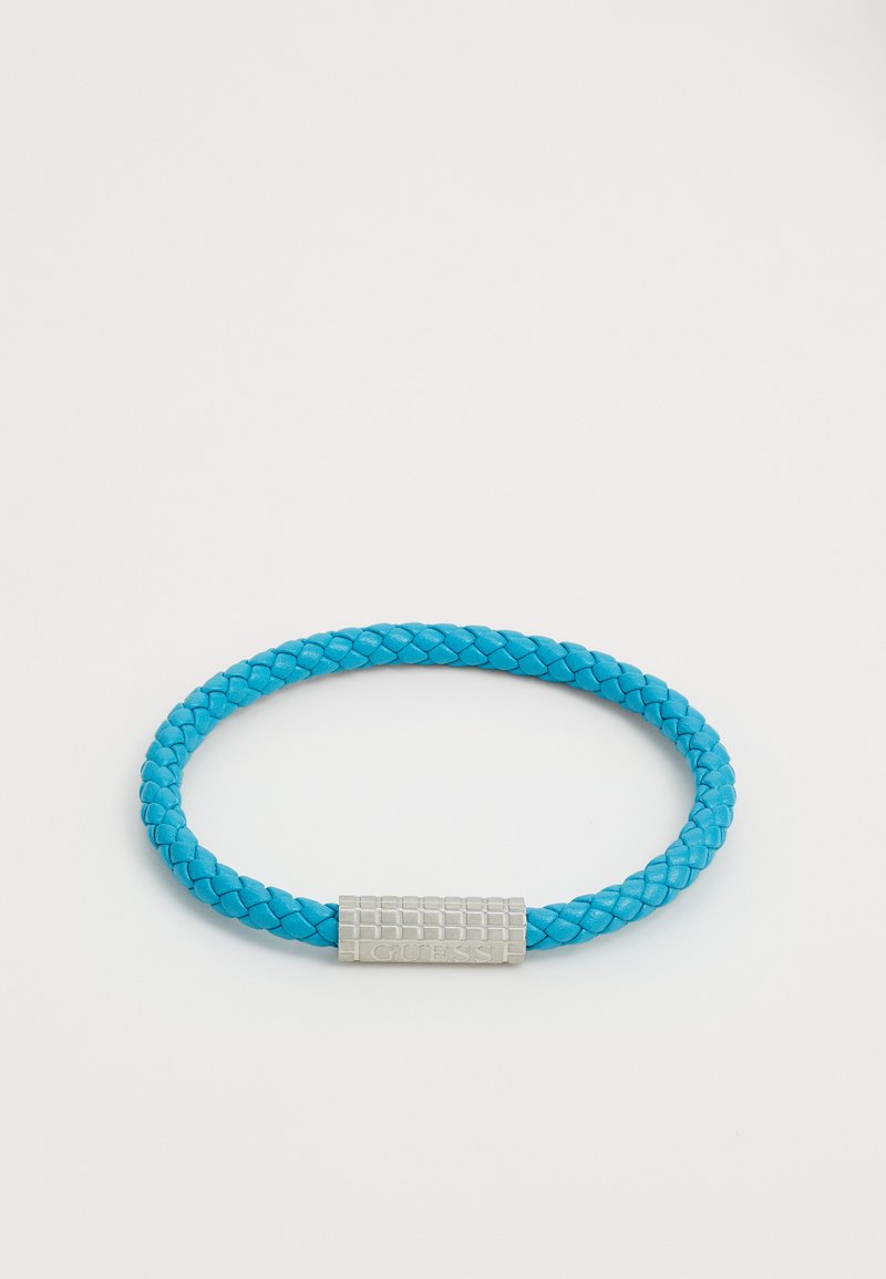 Pulsera de cuero trenzado azul con un cierre de plata texturizado. El cierre presenta una marca grabada y tiene forma rectangular.