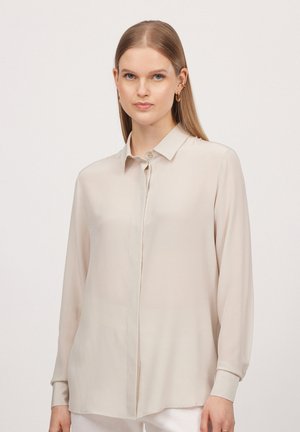 Lichtbeige button-up shirt met lange mouwen, gemaakt van gladde, transparante stof, en een klassieke kraag; subtiele glans en rechte snit aan de zoom.