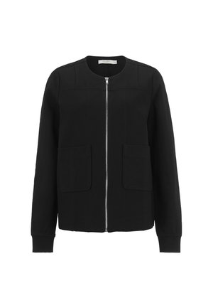 Veste noire à manches longues avec fermeture éclair frontale, col rond et deux grandes poches latérales, présentée sur un fond blanc.