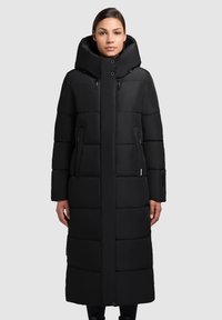 Dlouhý černý pufrový kabát s vysokým límcem, oversized kapucí, kapsami na zip po stranách a horizontálně prošívanými panely. Hladká textura, moderní design.