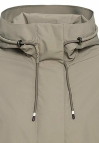 Light beige jacket featuring a high collar, drawstrings, and contrasting hardware accents suitable for outdoor wear.