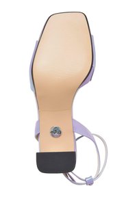 Lilla høyhælte sandal med en jevn såle, tynne stropper og en konturform. Har en sølvlogo på sålen og en strukturert underside.