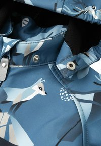 Blauwe waterdichte jas met een geometrisch foxpatroon, drukknoopsluitingen en een zachte binnenvoering. Het ontwerp bevat abstracte vormen en texturen.