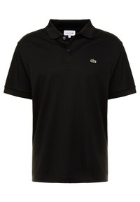 Polo noir à manches courtes en coton, avec un col rabattu et un petit logo crocodile vert sur la poitrine gauche.