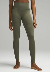 Olivgrüne High-Waist-Leggings aus dehnbarem Stoff, mit glatter Textur und figurbetonter Silhouette, endend an den Knöcheln.