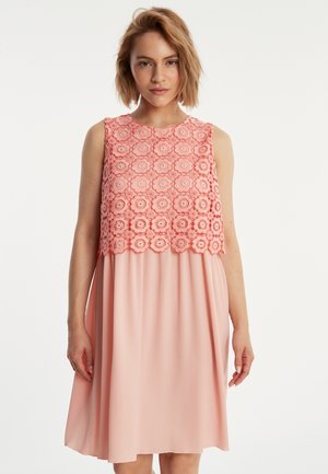 Robe sans manches avec un haut en dentelle florale corail, accompagnée d'une jupe rose unie fluide, fabriquée en tissu léger.