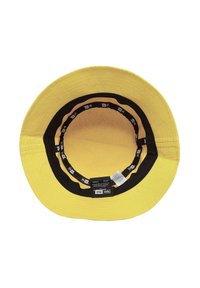 Gelbe Bucket-Hat mit breiter Krempe, ausgestattet mit einem schwarzen Innenfutter und Markenetiketten entlang des Umfangs. Das Material wirkt strukturiert.