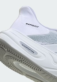 Bijela sportska cipela s teksturiranim mrežastim gornjištem, oznakom "RAPIDFIT" i sivom, rebrastom gumom s detaljima "CLOUDFOAM" u ulošku.