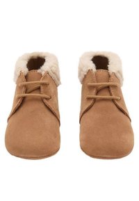 Bruna mockaskor med en mjuk krämfärgad pälsfoder, med rundad tå, snörningsdesign och en slät textur.