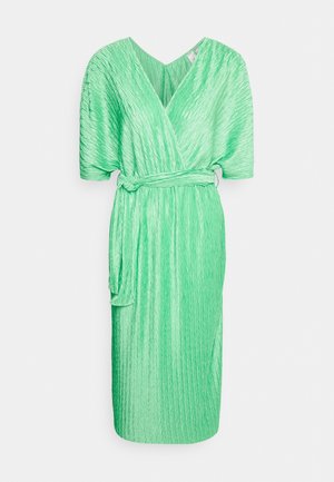 Zielona plisowana sukienka z dekoltem w serek, krótkimi rękawami i zawiązanym w pasie. Materiał ma teksturowane wykończenie i sięga do połowy łydki.