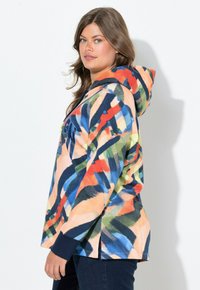 Felpa con cappuccio in stampa astratta multicolore con toni arancioni, blu e verdi. Presenta maniche lunghe e spacchi laterali.