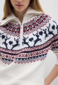 Maglione lavorato a maglia con base bianca e motivi Fair Isle in rosso, blu navy e grigio, dotato di colletto a mezza zip e texture morbida.