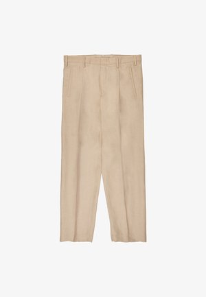 Pantalones beige a medida con trabillas para cinturón, bolsillos laterales con abertura, pliegue frontal y corte recto, colocados planos sobre un fondo blanco.