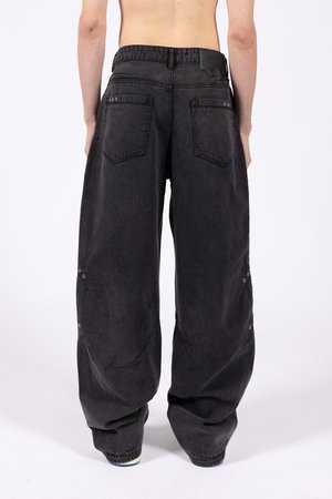 Črne jeans hlače ohlapnega kroja, z dvema zadnjima žepoma, vidnimi šivi in kovinskimi detajli na stranskih šivih.