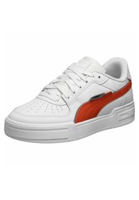 Valged sneakerid punaste aktsentidega ja tekstureeritud nahast. Omab perforatsiooniga varbaosa, lamedaid paelu ja paksu kummist tallat, millel on brändingu element.