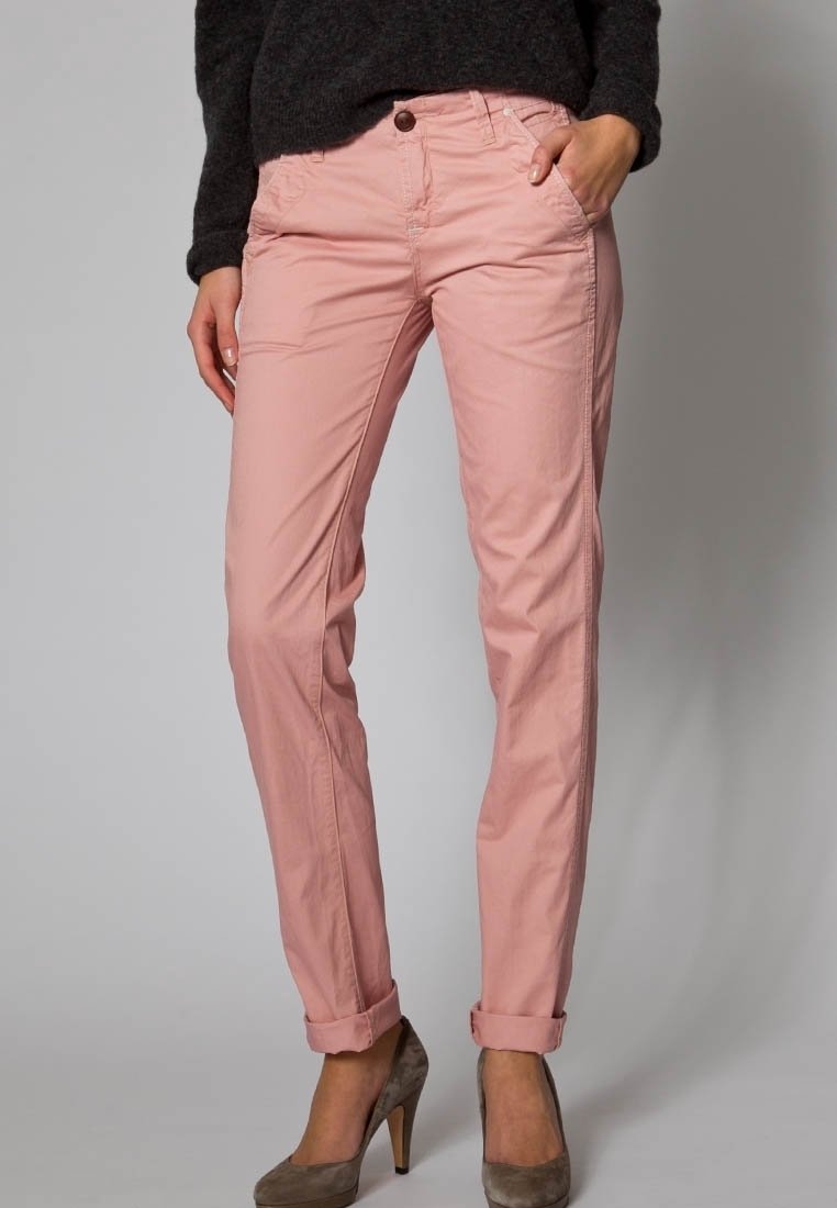 Ljusrosa bomullsbyxor med rak bendesign, utrustade med framfickor och upprullade benslut. Matchas med taupe högklackade skor.
