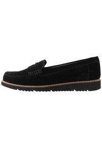 Melnas zamša loafers ar izvirzītu šuvju detaļu un viļņotu gumijas zoli. Sānu skats parāda gludu tekstūru un minimālistisku dizainu.