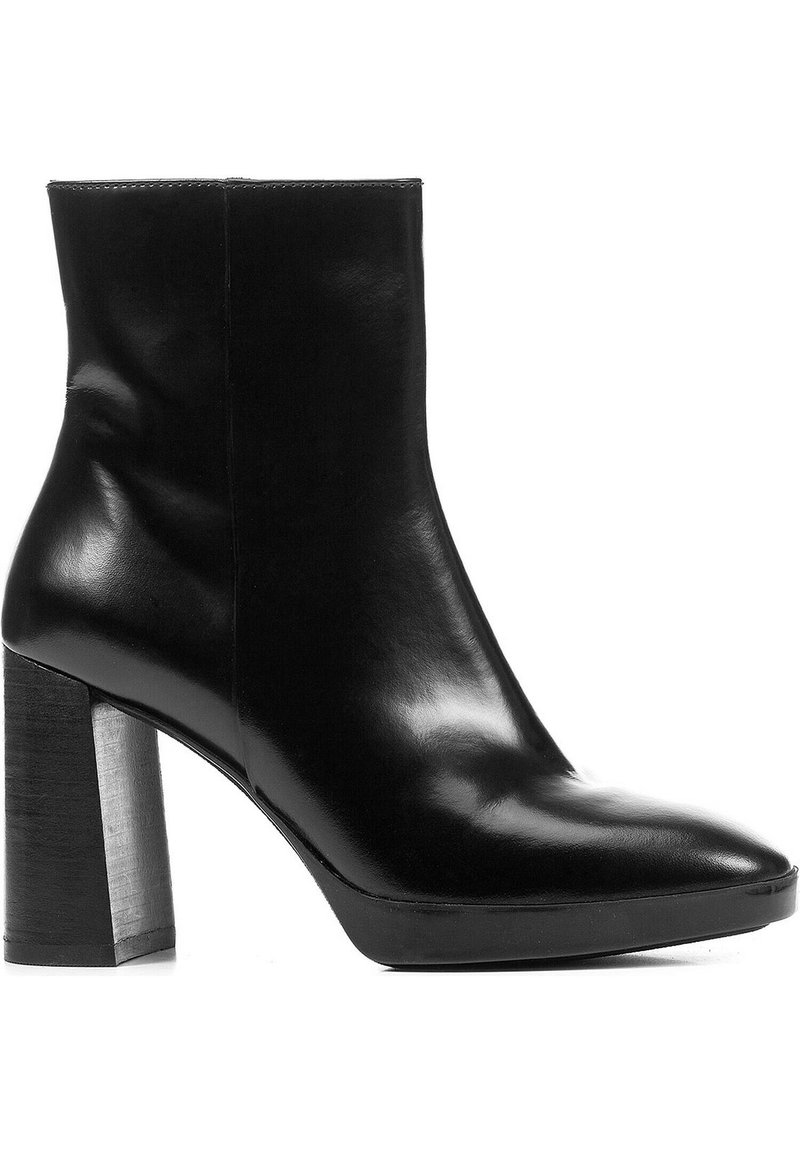 Bottine en cuir noir avec un bout pointu et un large talon block. Présente une texture lisse et des détails de couture minimes.