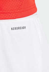 Röda och vita sportshorts i andningsbart material, med resårmidja och "AEROREADY"-logotyp på den nedre vita delen.