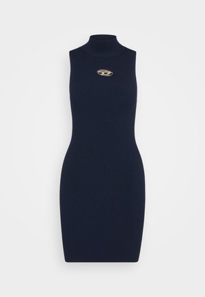 Mörkblå ribbad ärmlös klänning med hög halsringning och en gyllene emblemdetalj på bröstet. Materialet verkar mjukt och åtsittande.