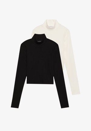 To lange ermer genser, en svart og en hvit, i en tettsittende design laget av et glatt, elastisk stoff.