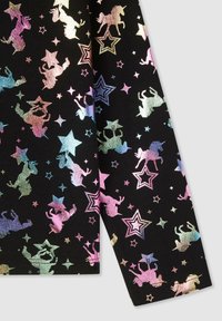 Czarna tkanina z błyszczącym wzorem jednorożców i gwiazd w pastelowych kolorach, z różnorodnymi kształtami i rozmiarami w designie.