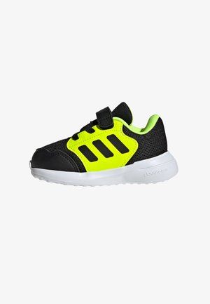 Sort atletik sko med neongul accentuer, mesh-overdel, teksturerede sorte overlays, velcro-rem og hvid yttersål med "cloudfoam."