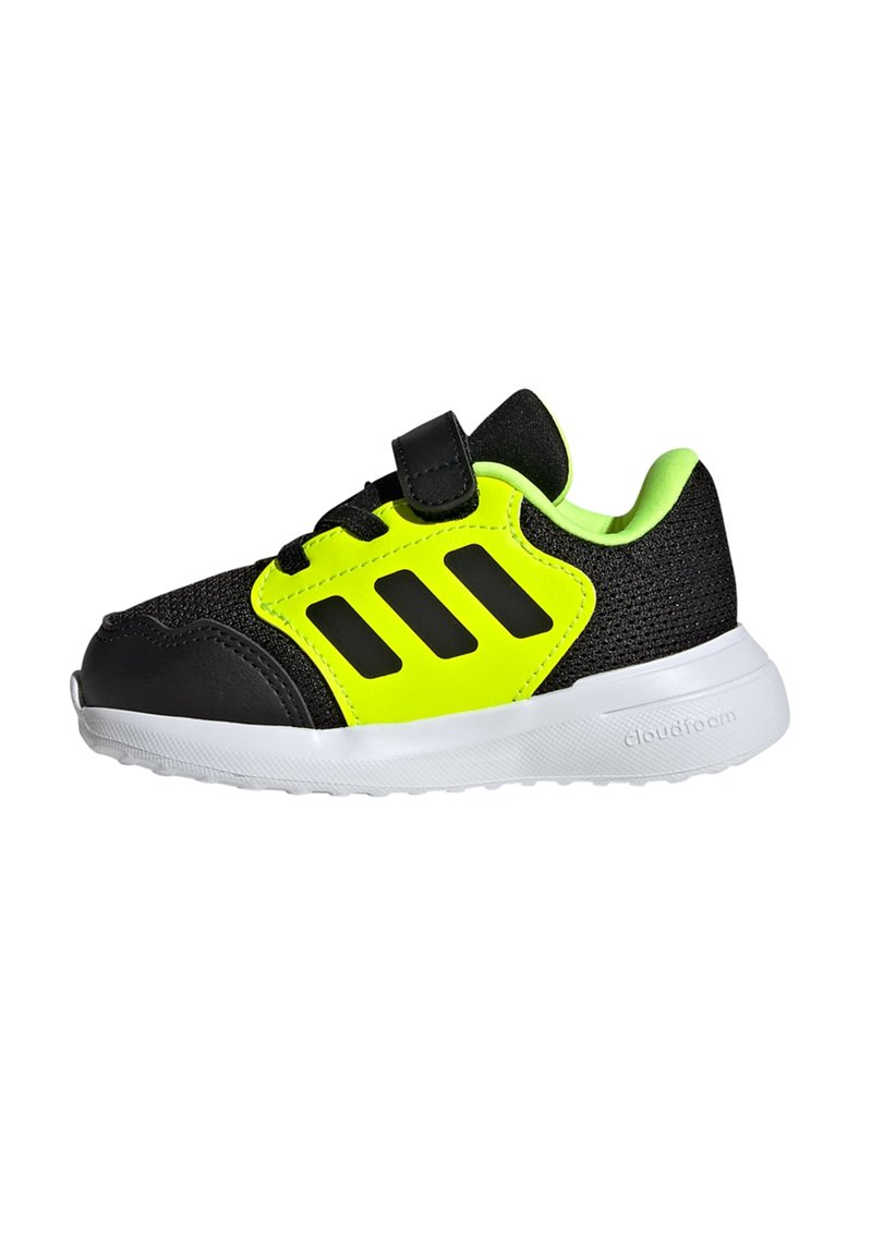 Black athletic shoe with neon yellow accents, mesh upper, textured black overlays, Velcro strap, and white outsole featuring "cloudfoam."