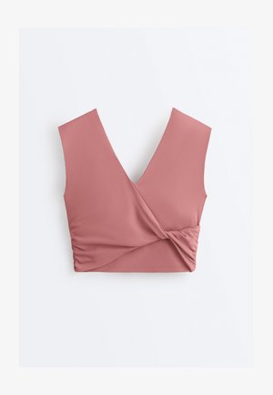 Brezrokavnik v pražno roza barvi, kratka majica z globokim V-izrezom in zvitim, nabranim detajlom na eni strani ob robu.