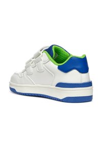 Witte leren schoen met groene en blauwe accenten, voorzien van een gestructureerde blauwe rubberen zool, klittenbandsluitingen en een gevoerde kraag.
